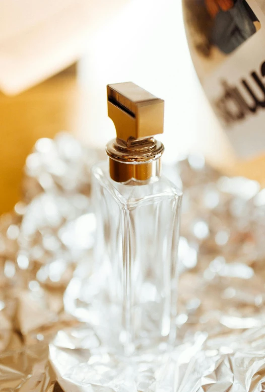 a bottle of perfume on a plate with a silver plate cover