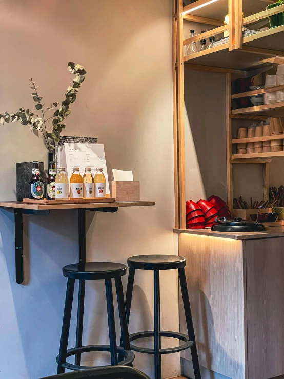 two bar stools in front of a counter with products on it