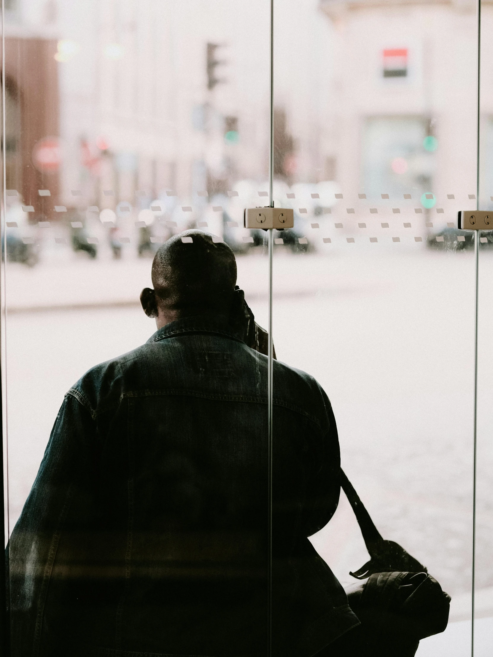 a silhouette of a woman sitting in a chair looking out a window