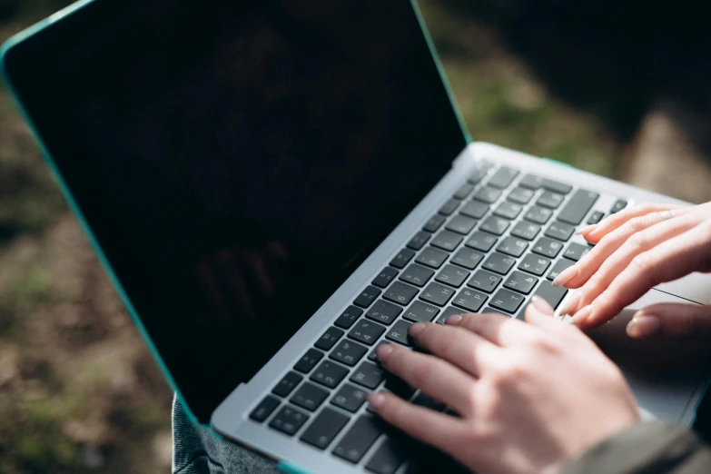 a woman typing on her laptop outdoors