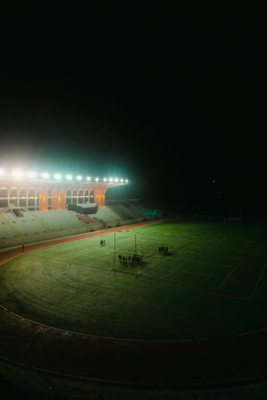 a green grass field with two large lights