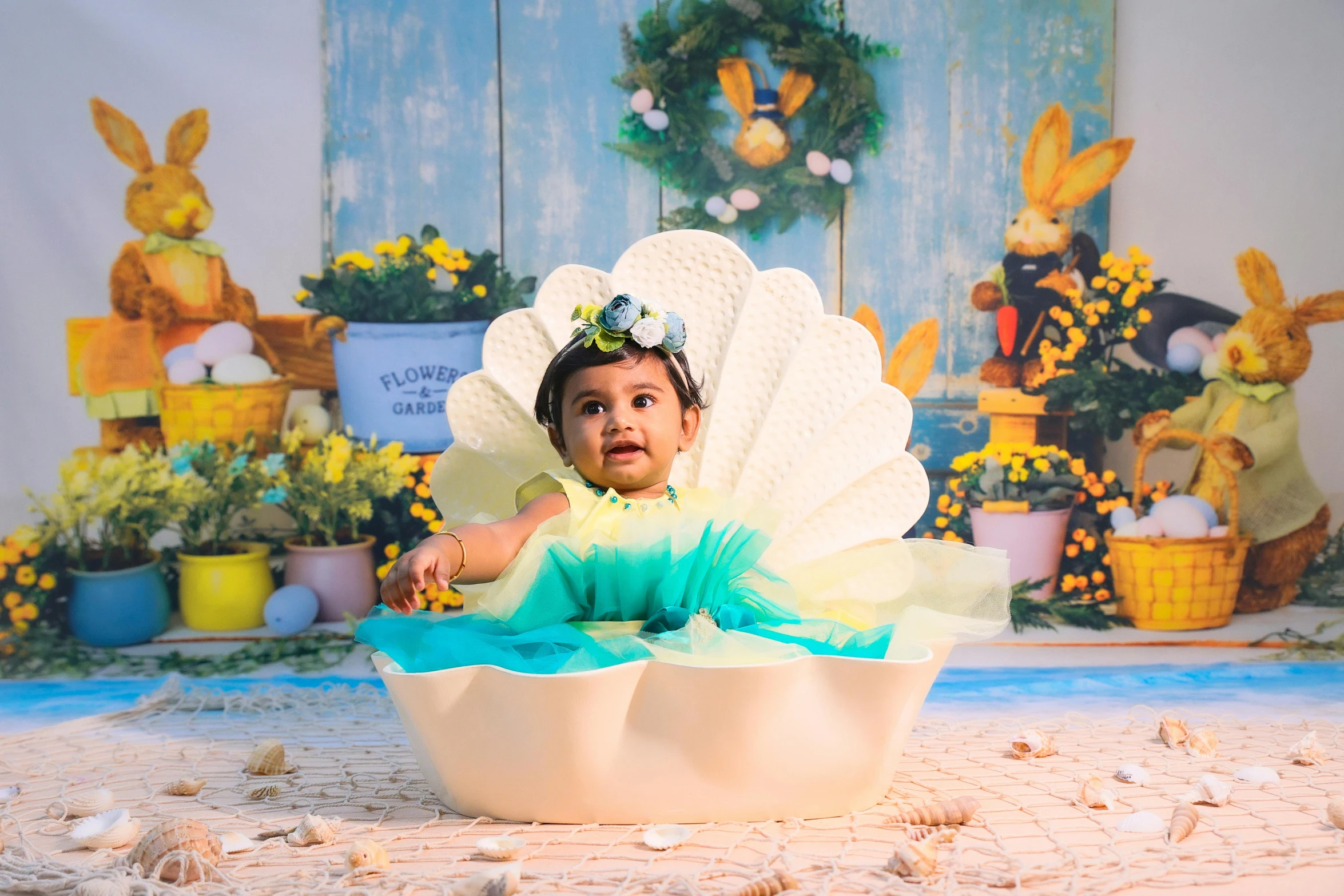 a baby girl wearing a big shell like pose for the camera