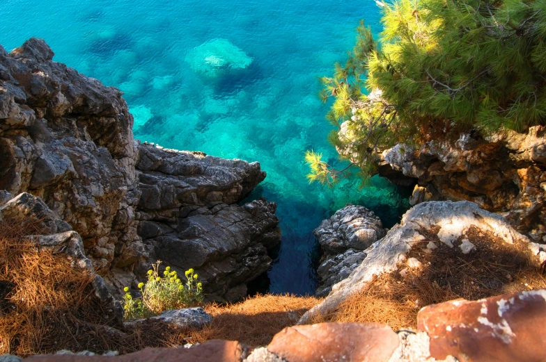 the clear blue water in the sea near some cliffs