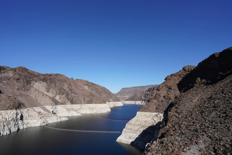 a body of water surrounded by mountains under a blue sky