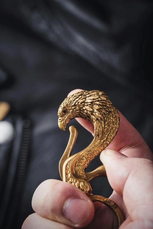 person holding a gold snake shaped piece in their hands