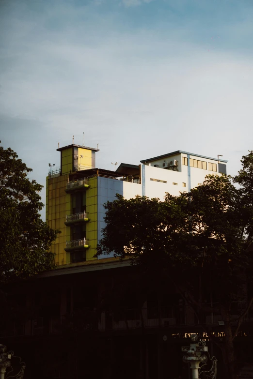 two white buildings are next to green trees