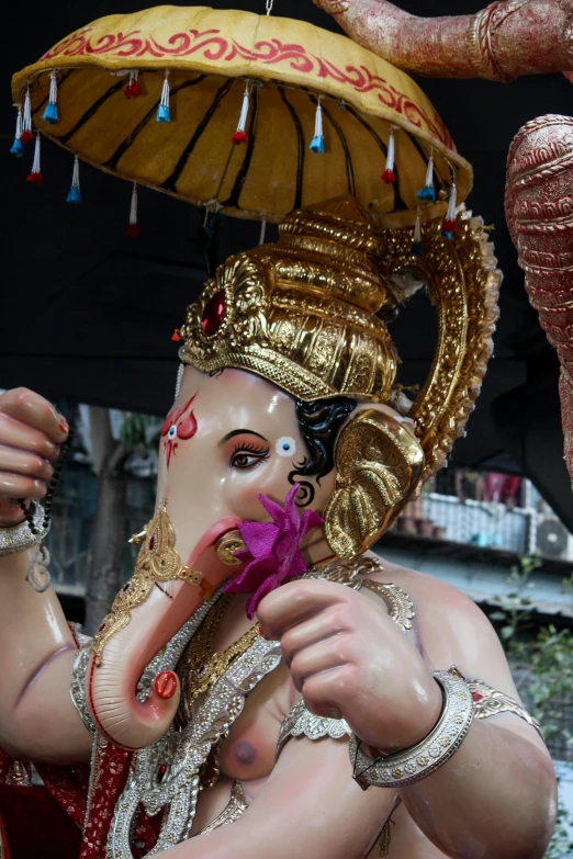 a statue with a hat is decorated in gold