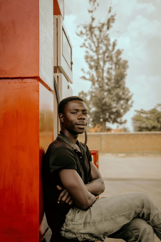 man leaning against wall with legs crossed in place