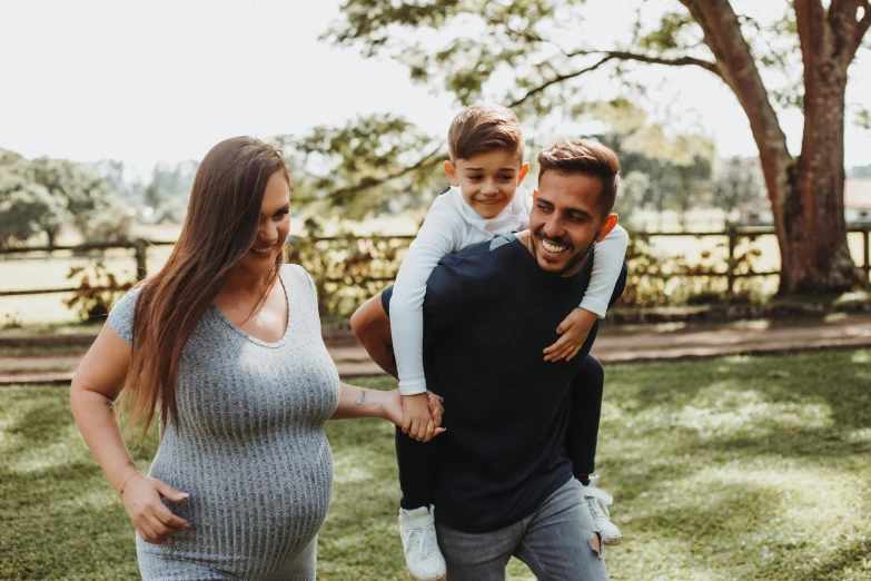 a young man is smiling at the camera, while his mother and dad are holding him