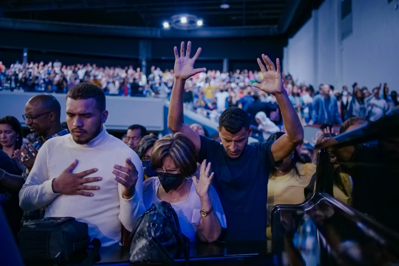 two people holding their hands in the air at a convention