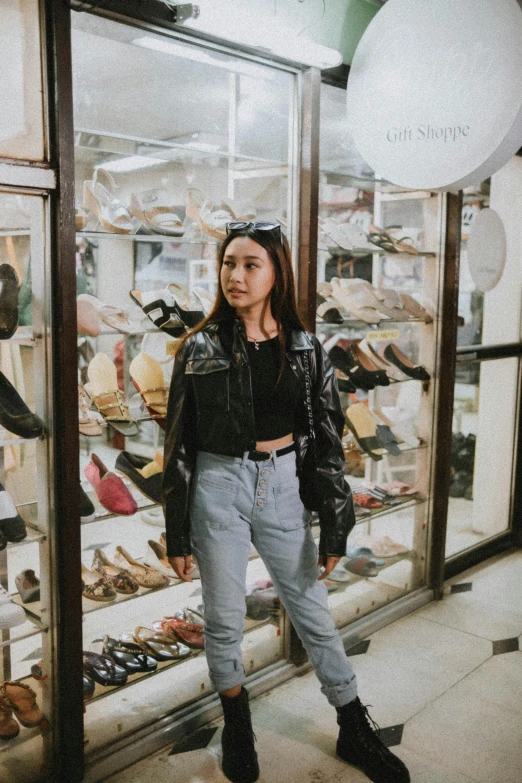 a young woman standing inside a store looking into the window