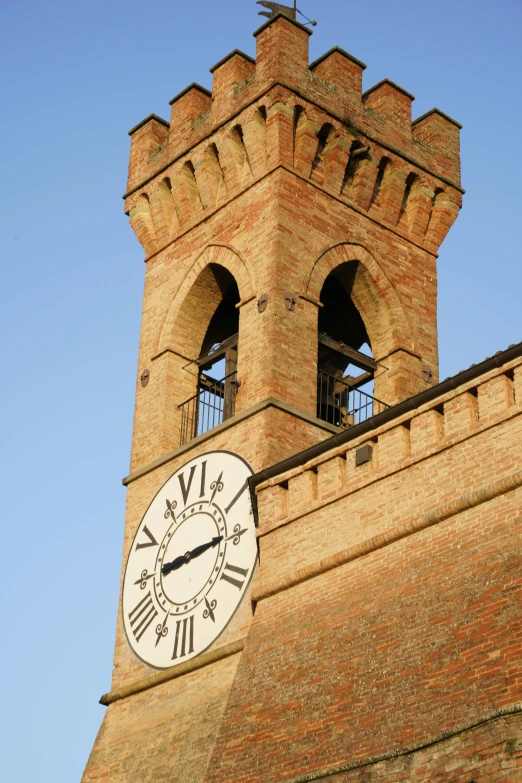 a brick clock tower has a cross on the top