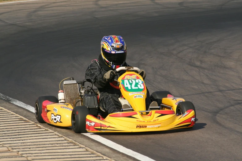 a man with helmet riding on a go kart