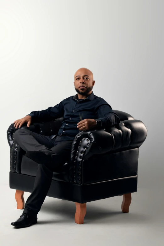 a man is posing on an old leather chair