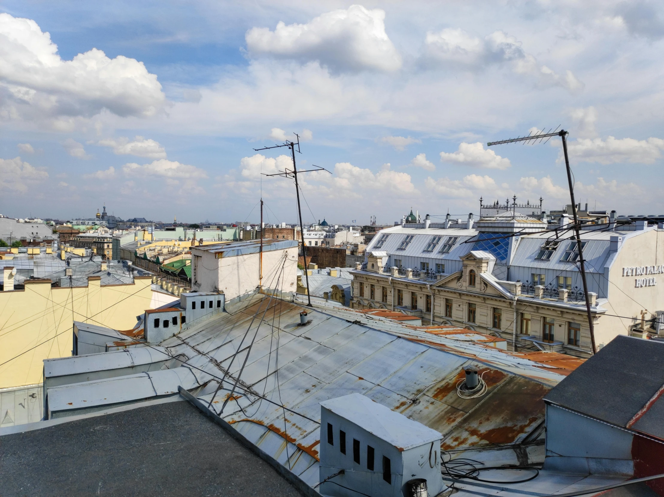 some roofs with houses on the other side and a big building