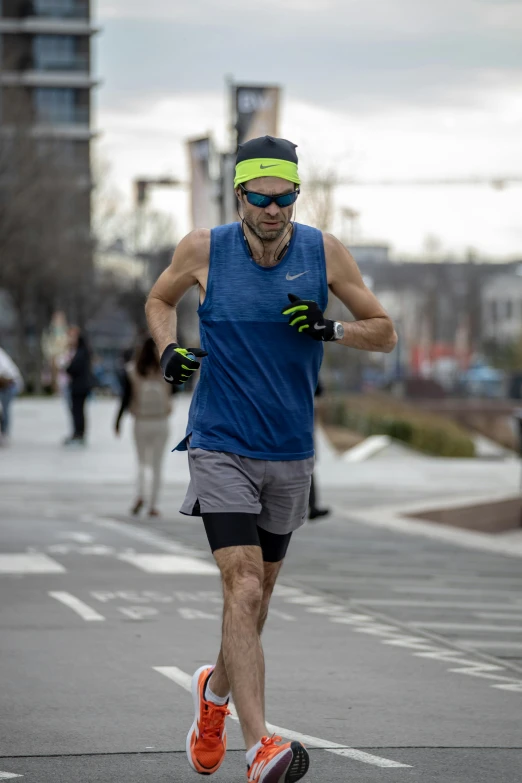 a man in running gear and safety glasses running