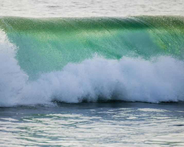 a big wave in the ocean is crashing