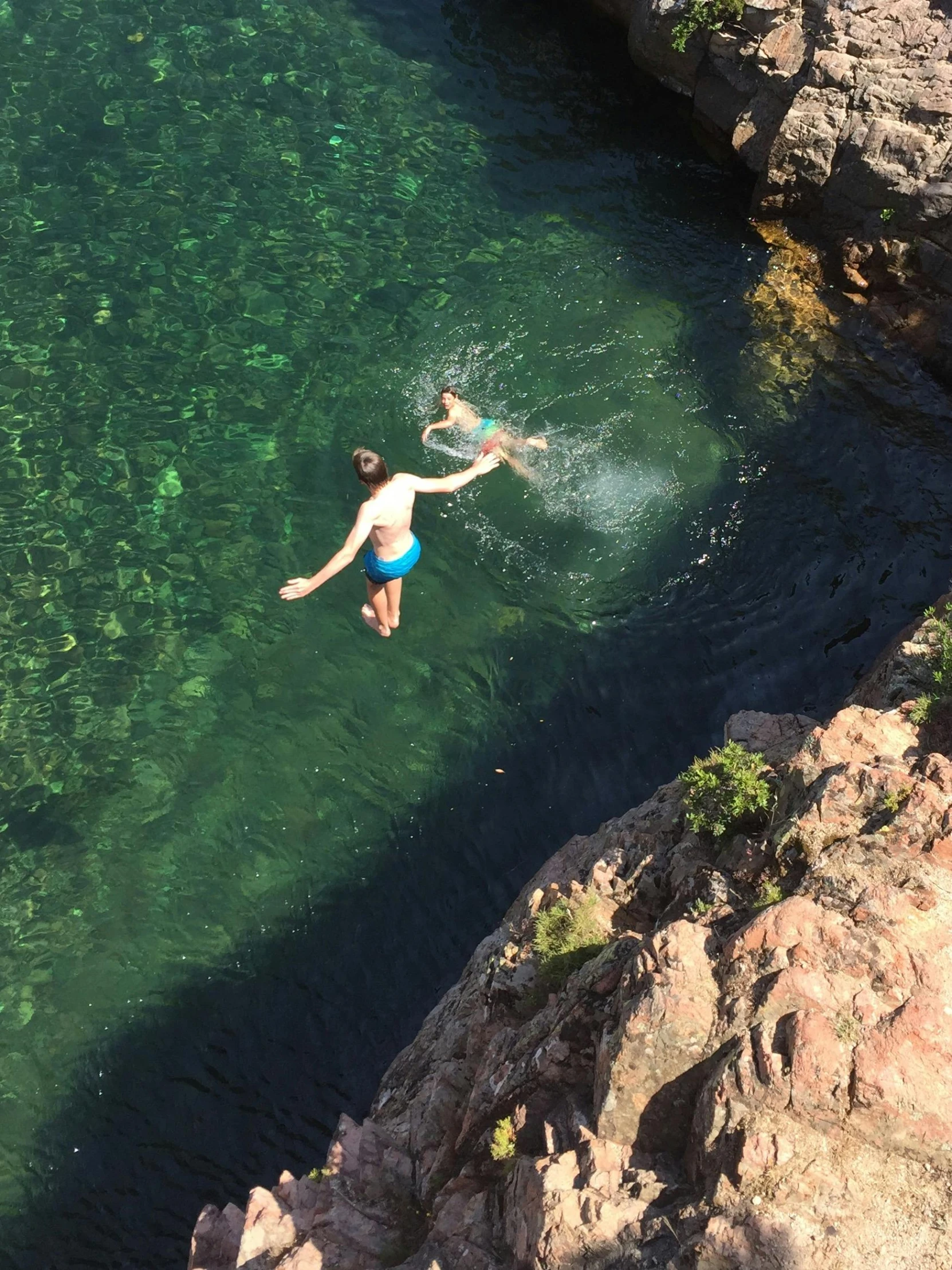 two people in a body of water jumping