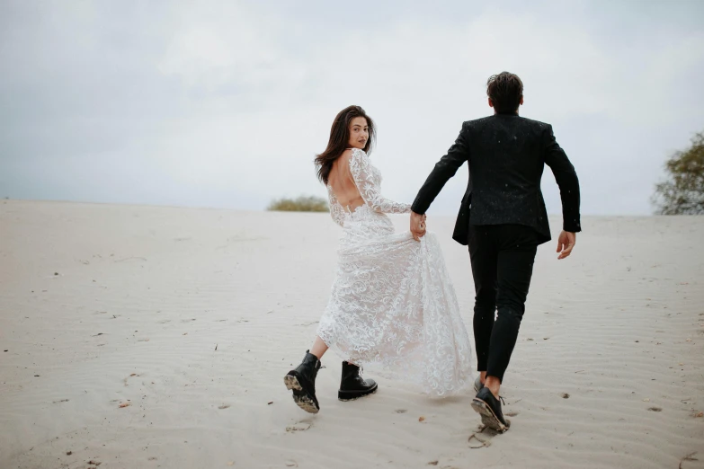 a couple is walking together through a sand dune