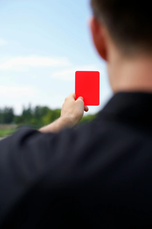 a man is flying a red square with his hand