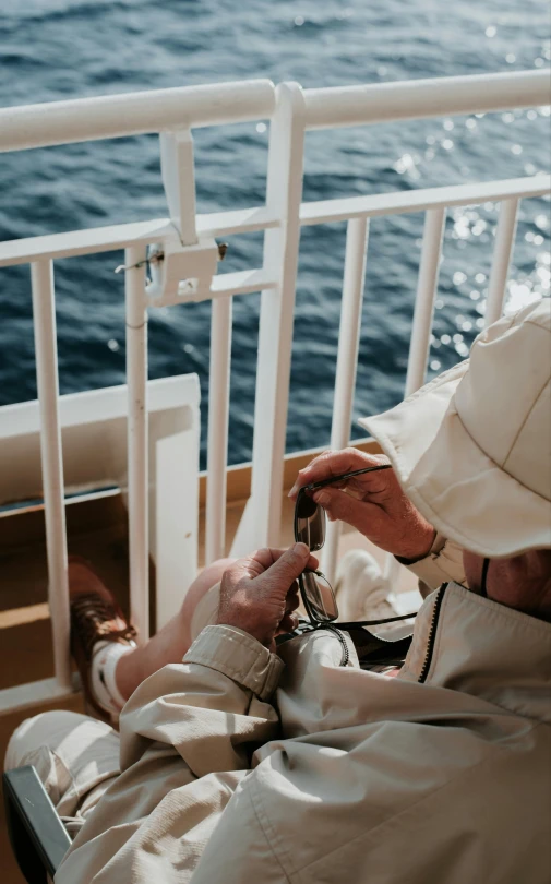 the priest is adjusting his religious rosary while he looks at the ocean