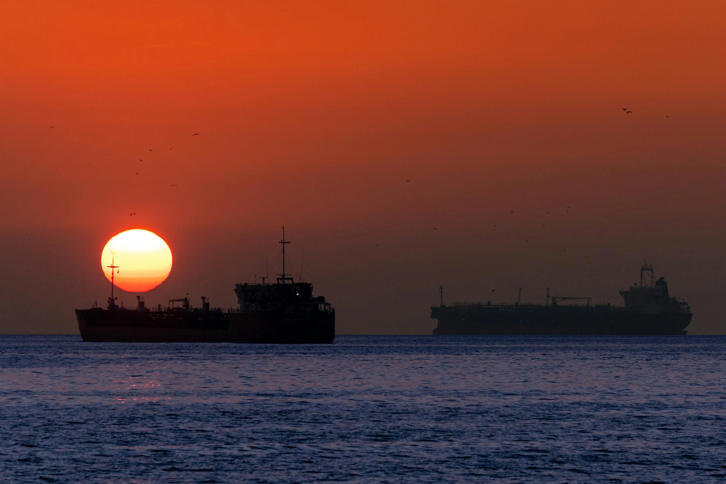 sunset with two ships passing each other