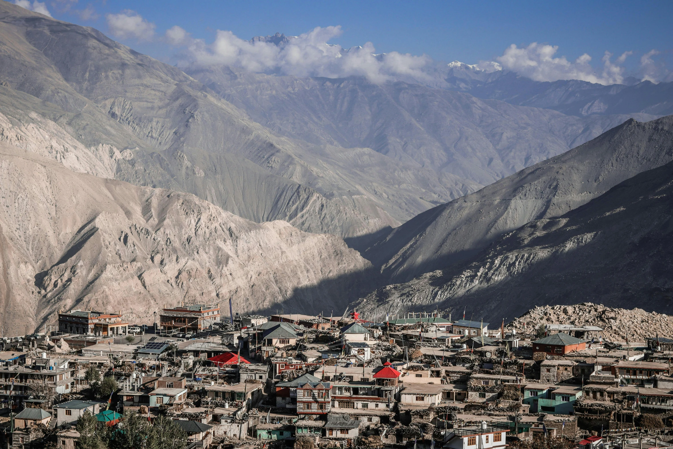 a small village on a cliff surrounded by mountains