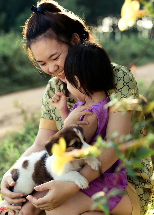 the woman is holding a baby and she is holding her puppy