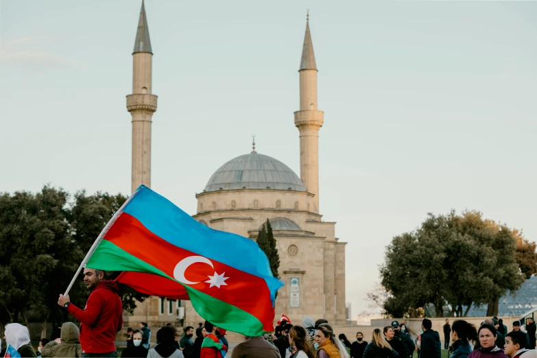 a large flag in front of two towers