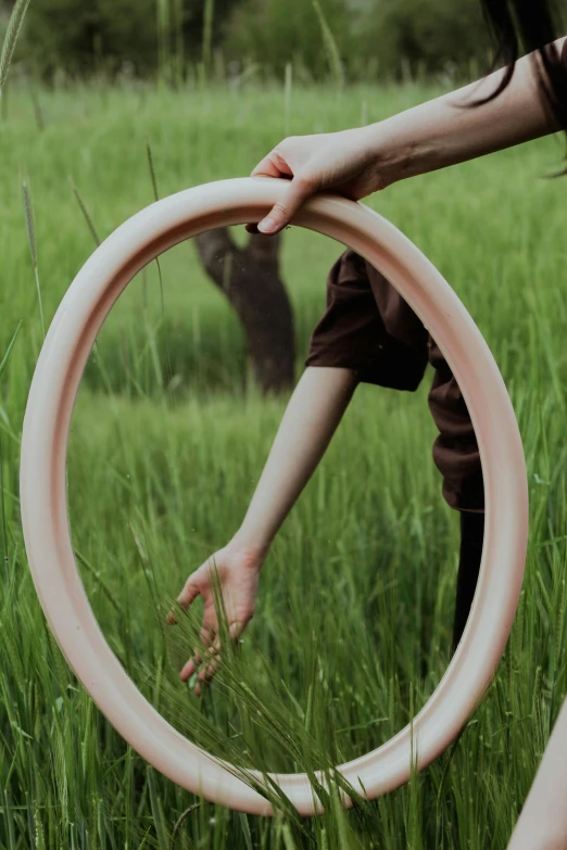 a person holding a circular object in a grassy field