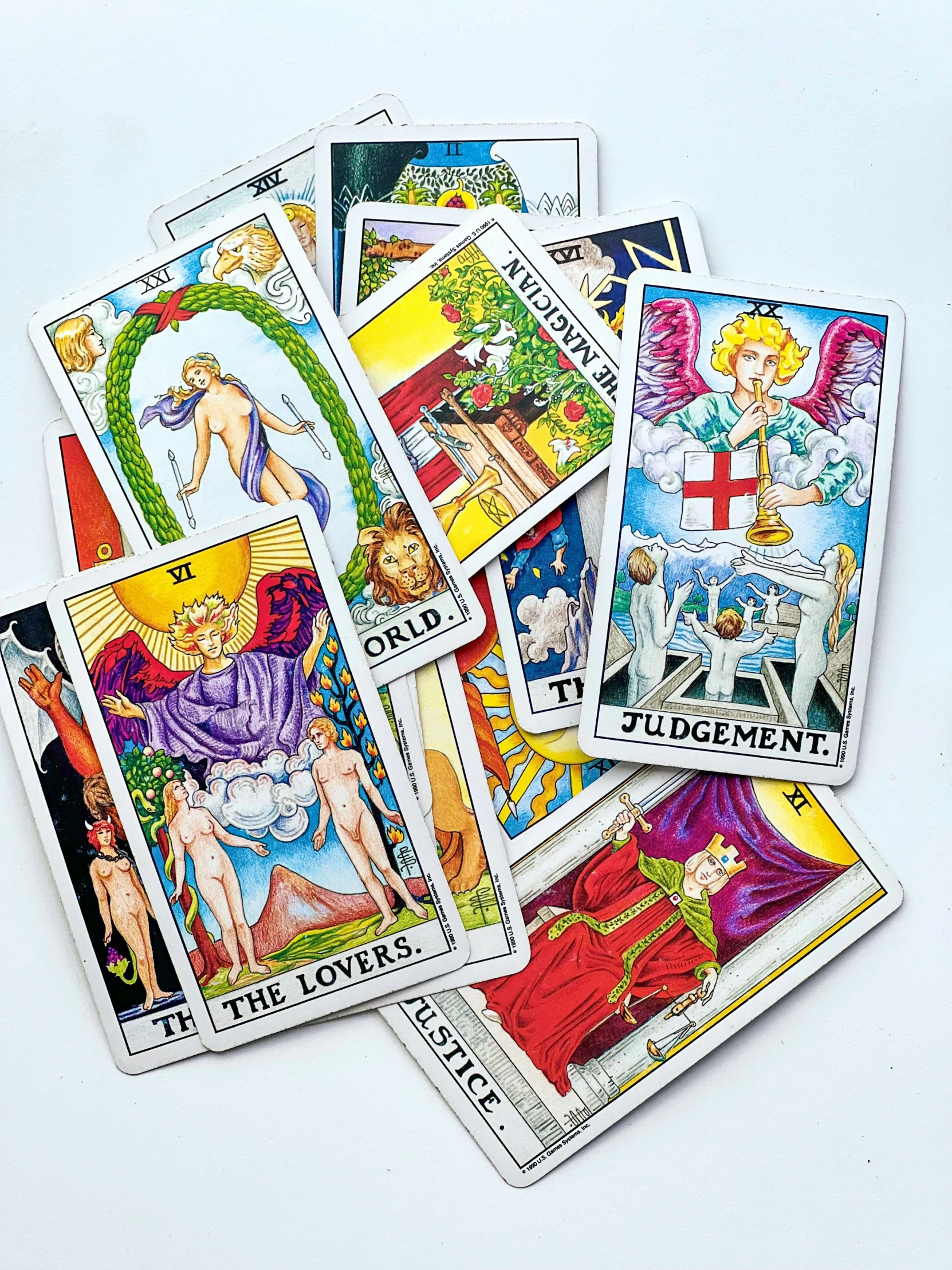 many different tarot cards sit on a white surface
