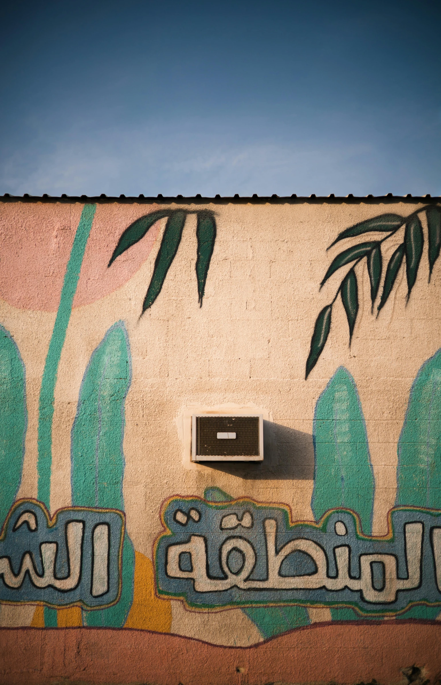 a painted wall with palm trees in the background