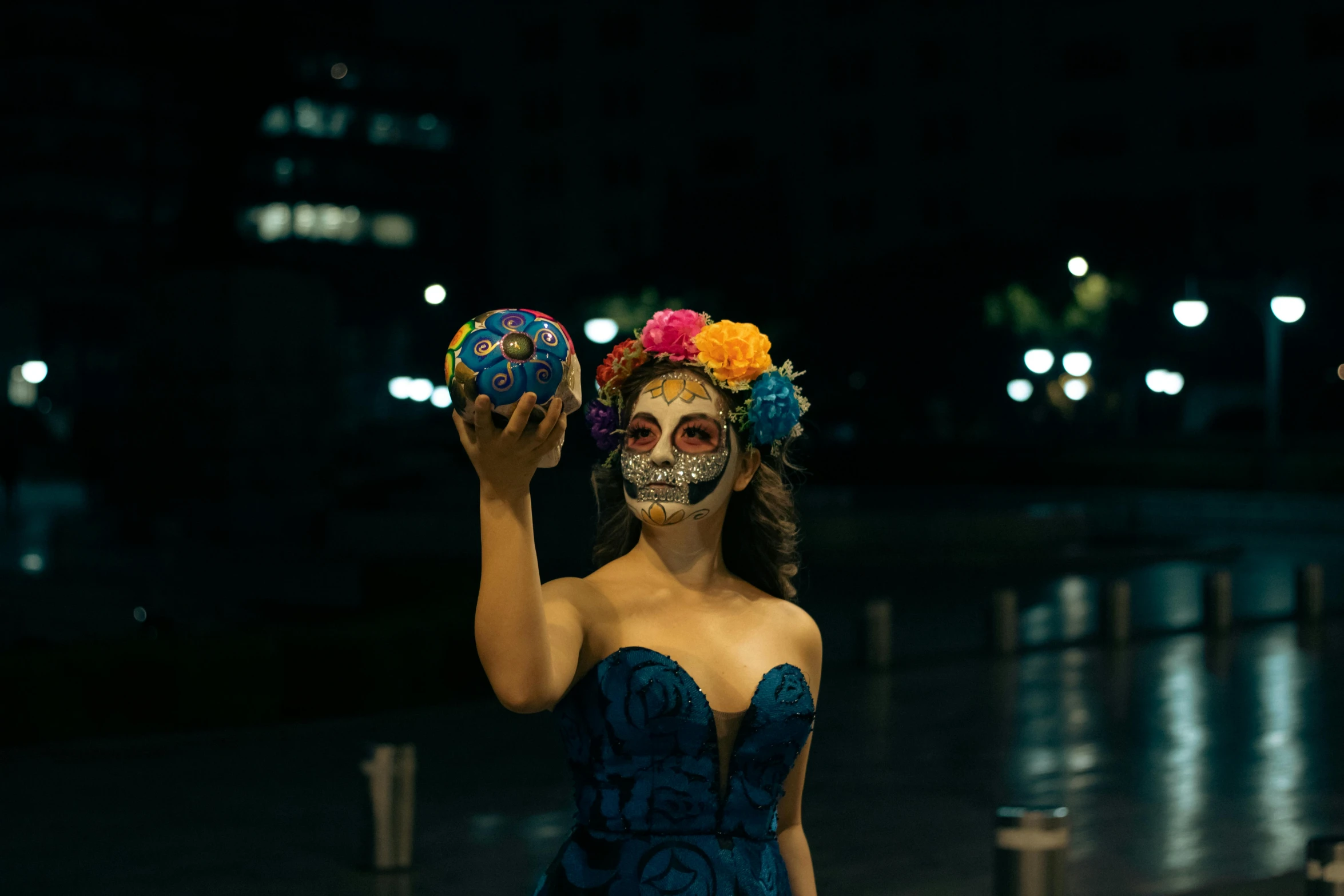 a woman in the dark holding two skulls