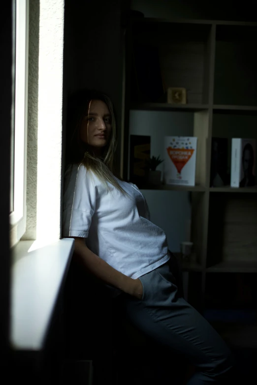 a woman leans against the window in an empty room