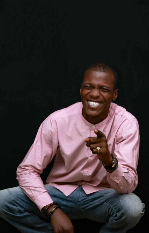 a man is posing for a po while wearing a pink shirt