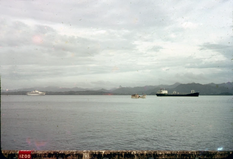 the ocean has two large ships in the distance