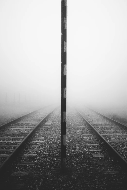 the pole stands tall in the middle of a foggy field