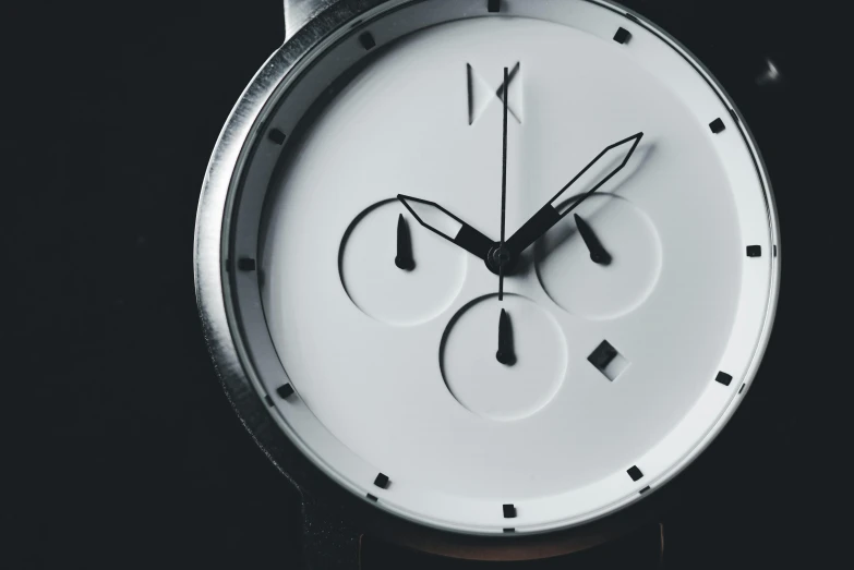 an analog watch with white face and black hands