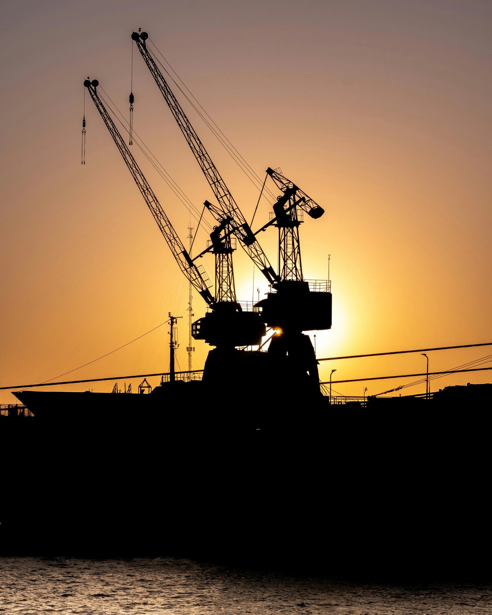 a boat with multiple cranes is out on the water