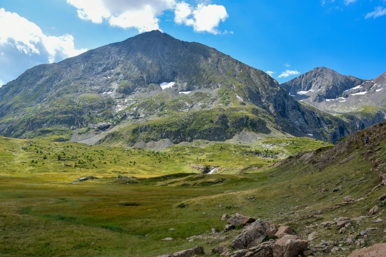 a mountain range with grass and rocks on either side