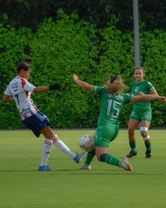 two soccer players with green uniforms colliding for a ball