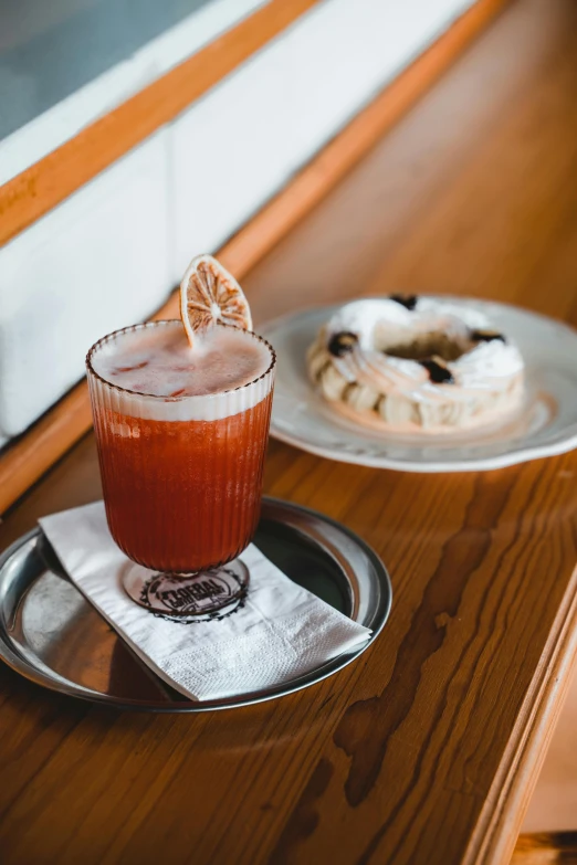 the beverage on the plate is near a half eaten donut