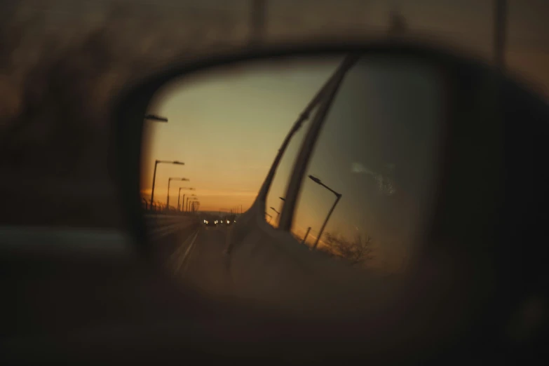 an image of sunset seen in side view mirrors