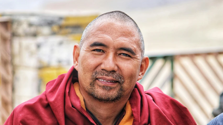 a monk is standing in the sun, smiling