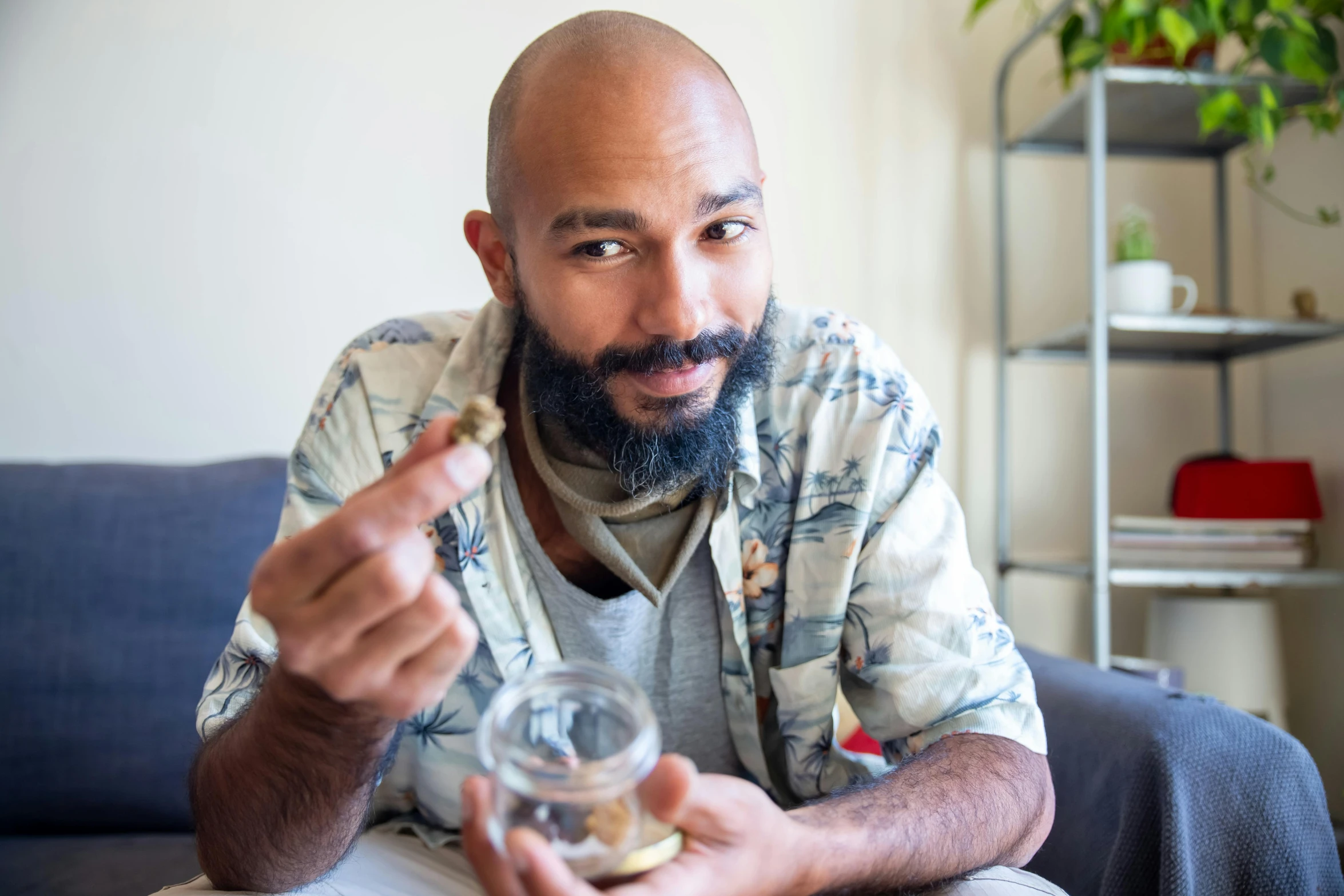 a man holds a glass jar with coins in it