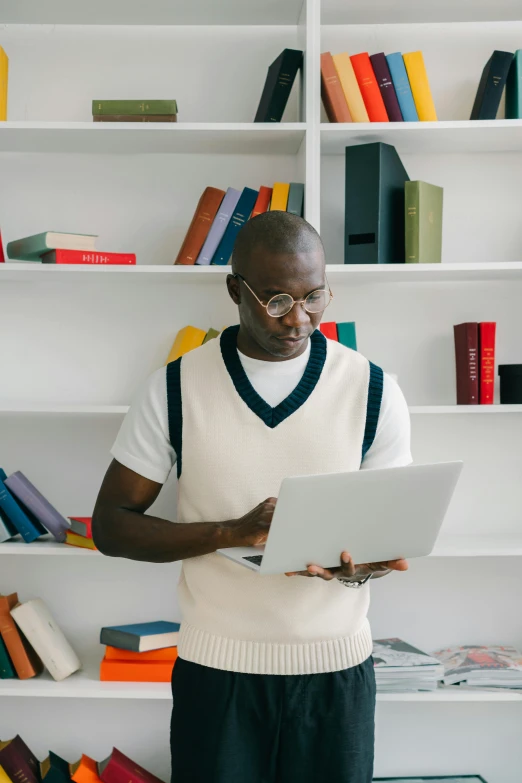 a man with glasses looks at his white tablet