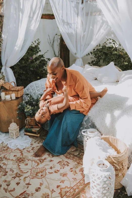 man on a bed with an infant holding him and other stuff