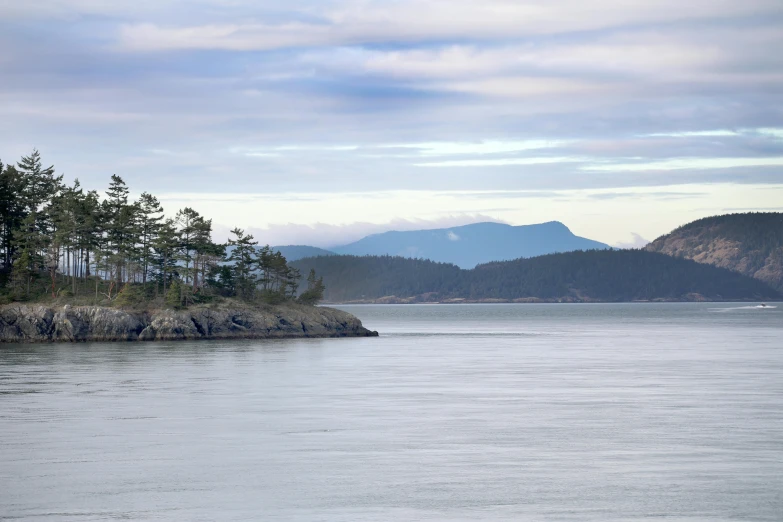 a boat is traveling on a lake with mountains in the background