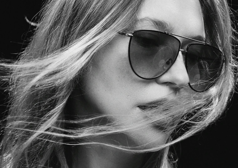 a woman with blond hair and glasses looking down