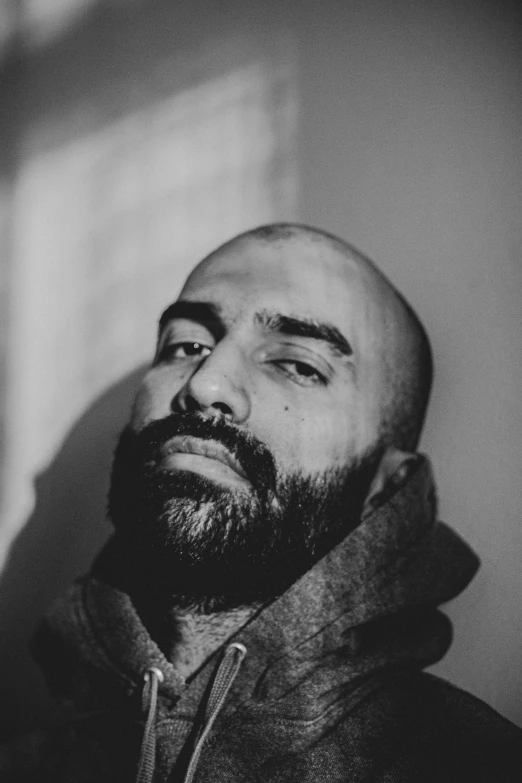 man with beard wearing jacket standing in the sun